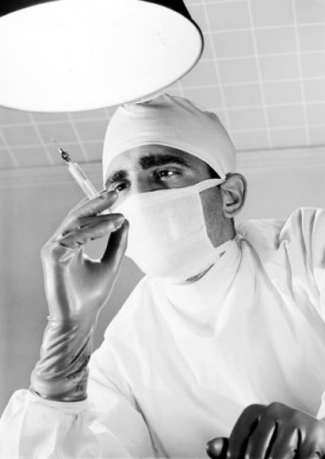 Surgeon holding syringe in operating room Canvas Art - (24 x 36)
