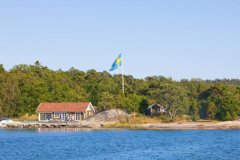 Sweden Stockholm - House on island in archipelago with swedish flag on pole Canvas Art - Panoramic Images (36 x 12)