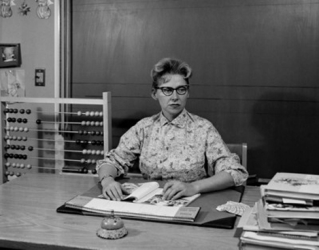 Teacher sitting at desk in classroom Canvas Art - (24 x 36)