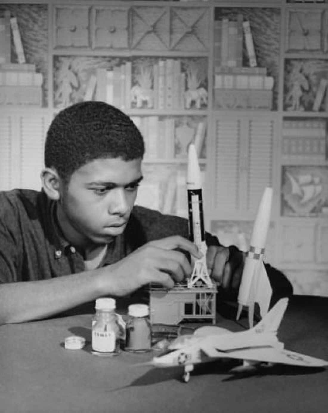 Teenage boy making models of an airplane and rockets Canvas Art - (24 x 36)