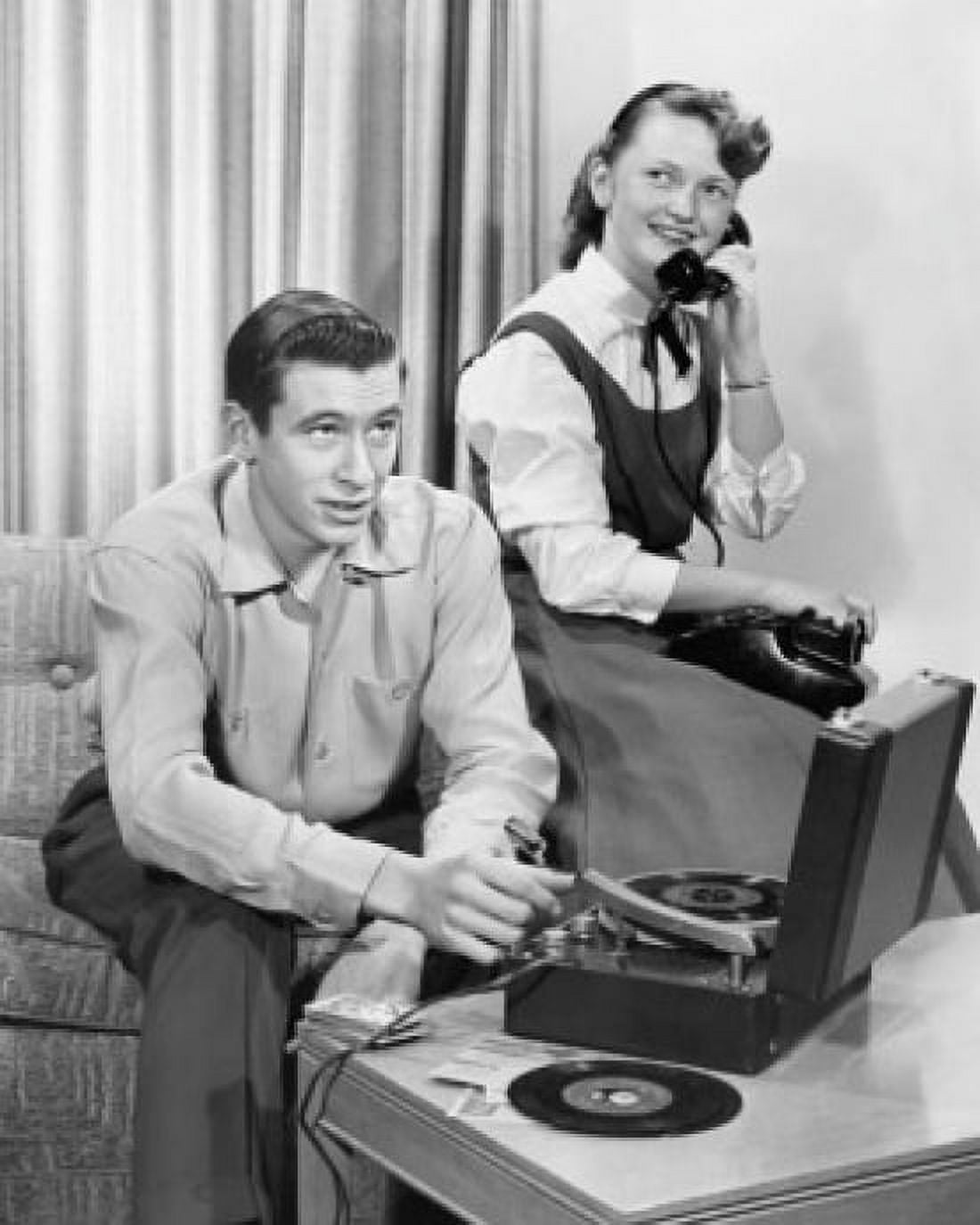 Teenage boy playing record and teenage girl talking on telephone Canvas Art - (18 x 24)
