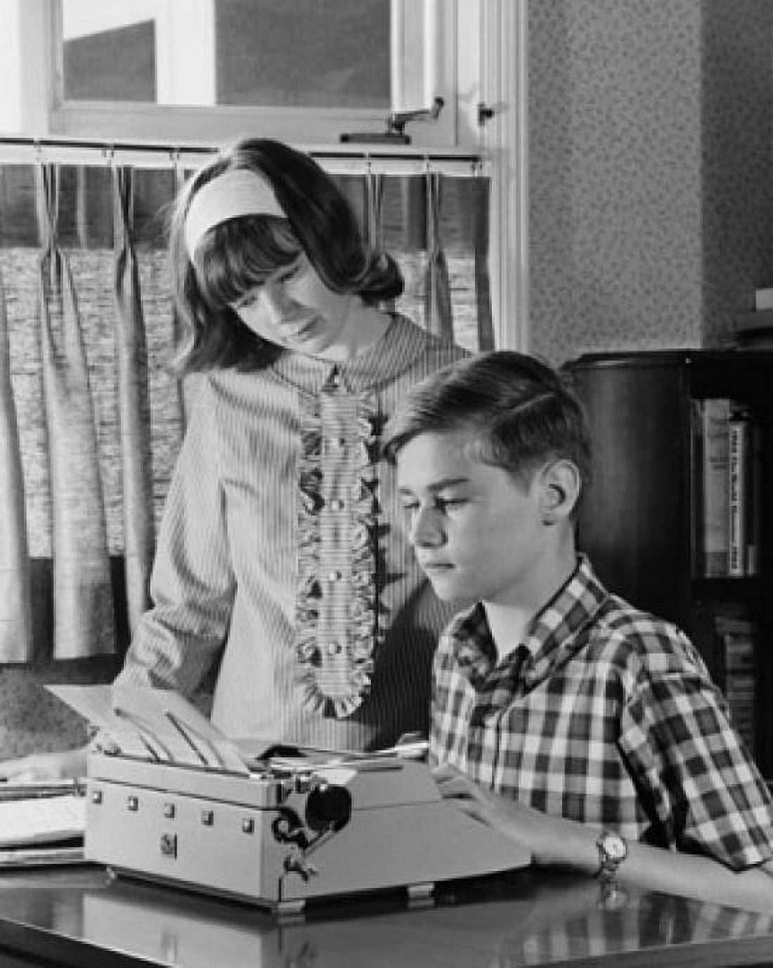 Teenage boy typing on a typewriter and his sister standing beside him Canvas Art - (24 x 36)