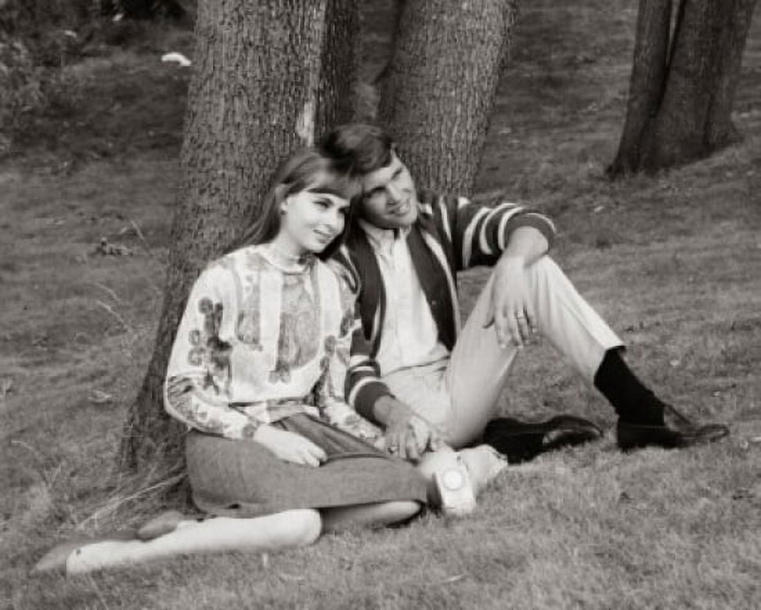 Teenage couple sitting in park listening to radio Canvas Art - (18 x 24)