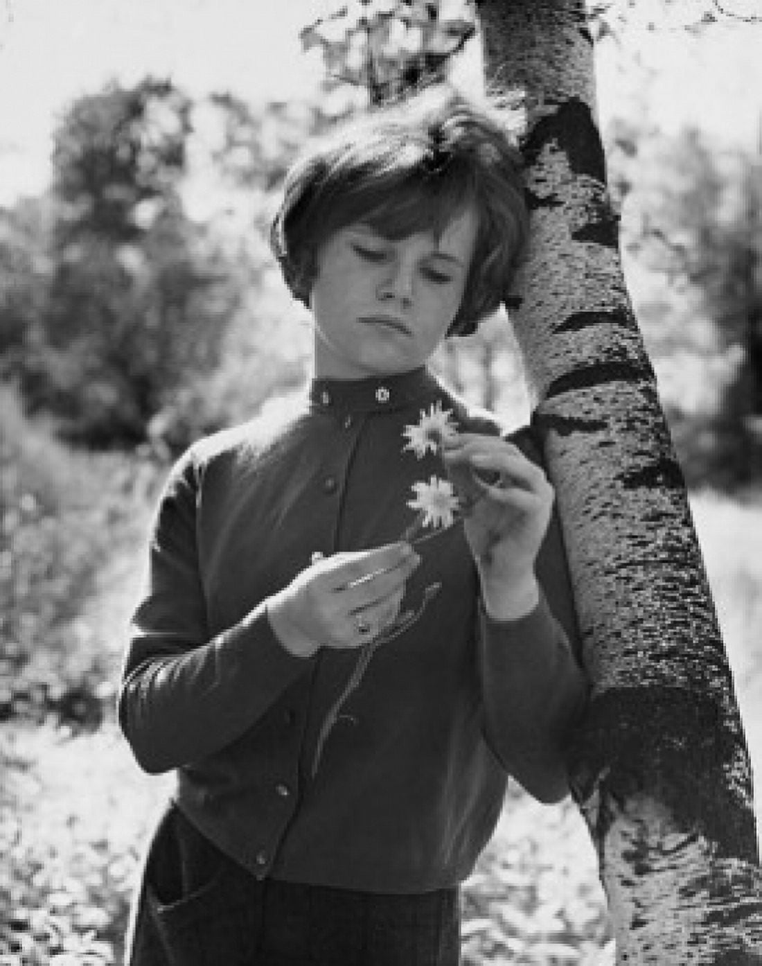 Teenage girl leaning against a tree and holding a flower Canvas Art - (18 x 24)