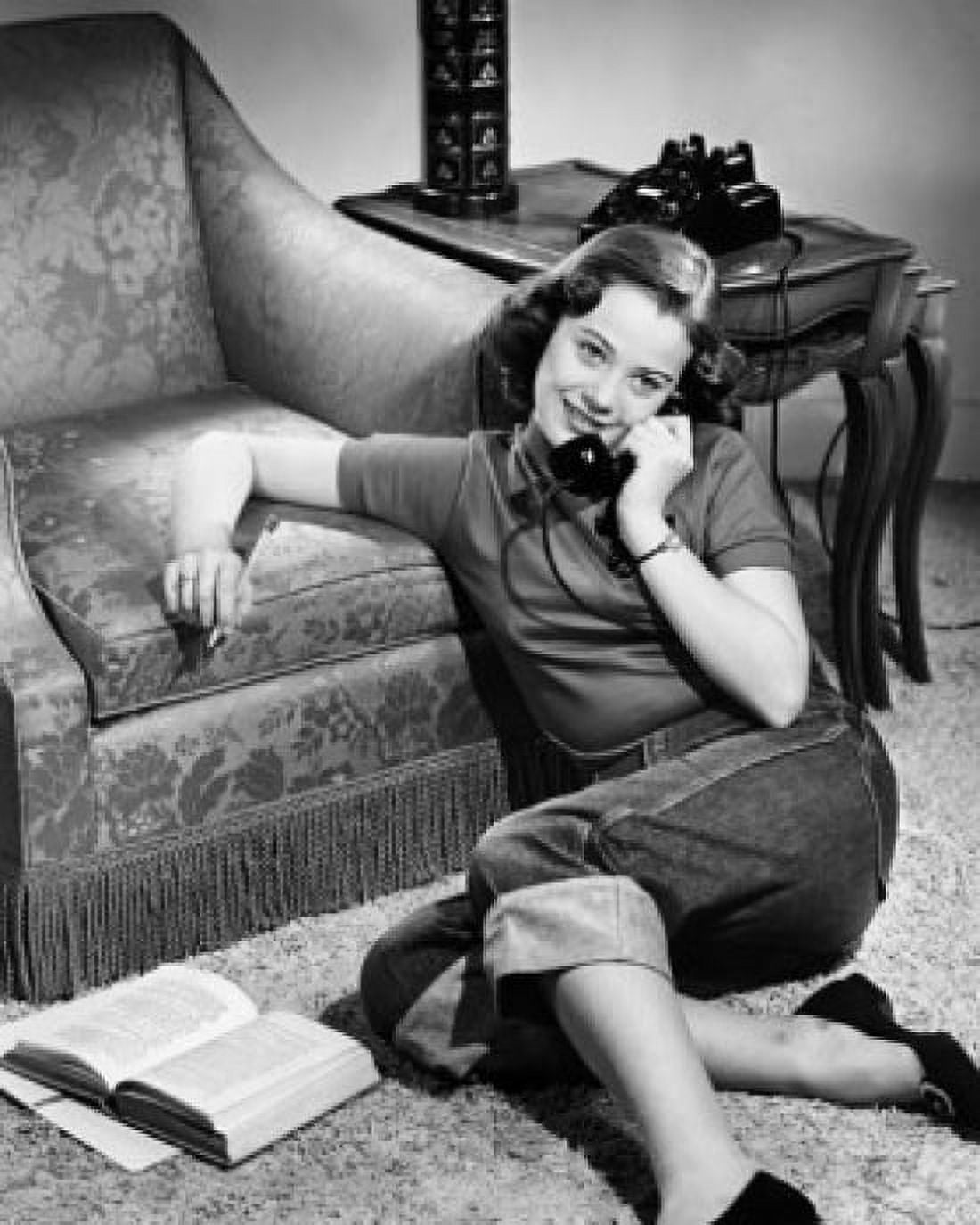Teenage girl leaning against an armchair and talking on the telephone Canvas Art - (24 x 36)