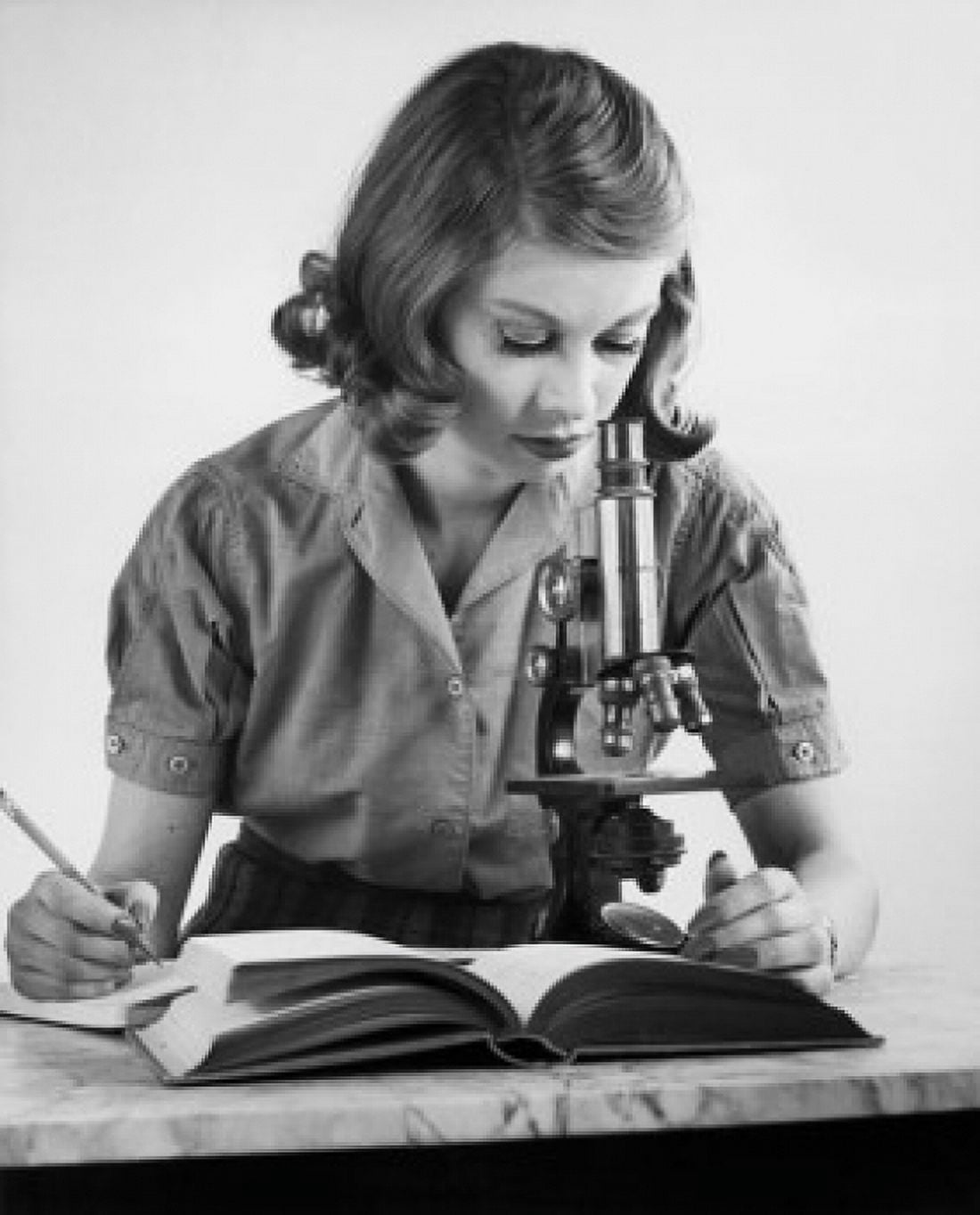 Teenage girl looking through a microscope Canvas Art - (24 x 36)
