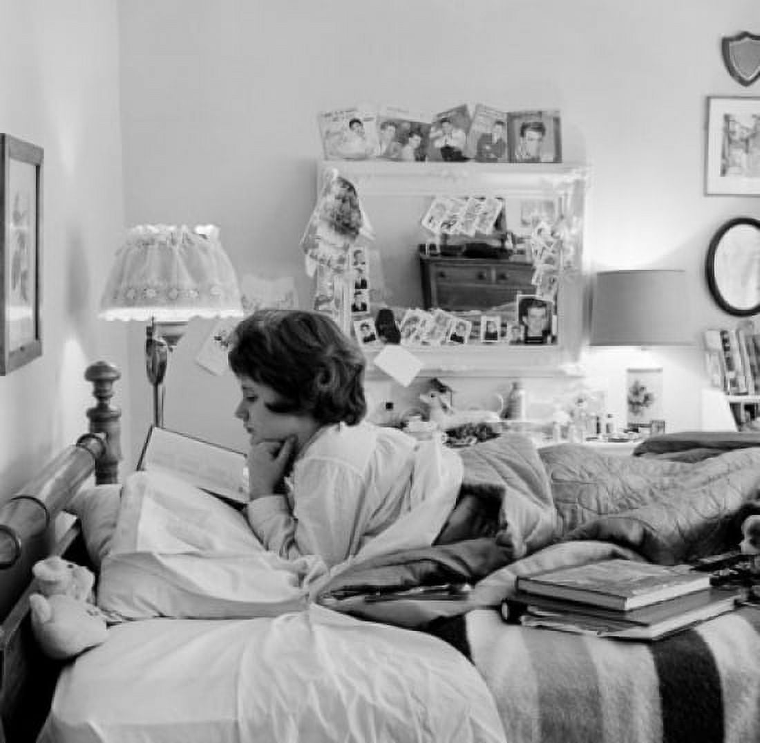 Teenage girl lying in bed and reading Canvas Art - (24 x 36)