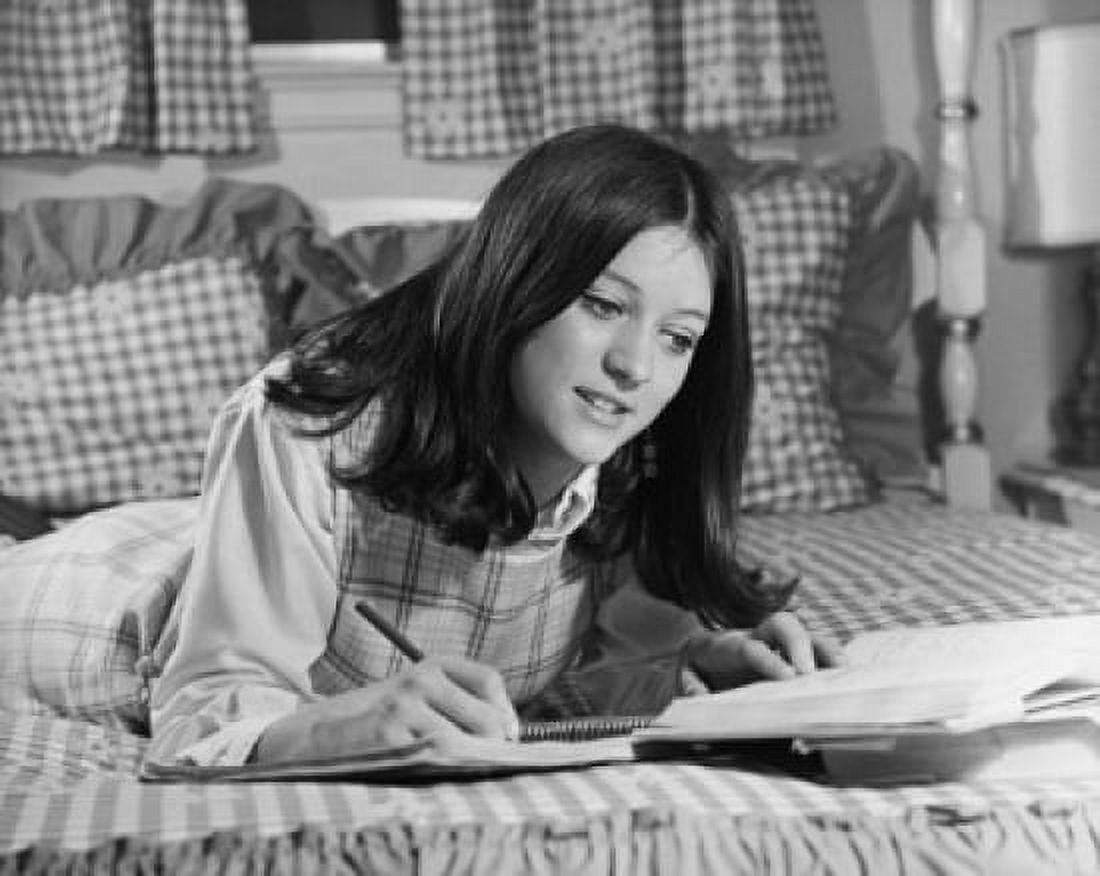 Teenage girl lying in the bed and writing in a spiral notebook Canvas Art - (24 x 36)