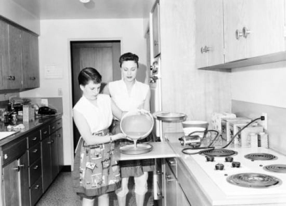 Teenage girl preparing food in the kitchen with her mother standing beside her Canvas Art - (24 x 36)