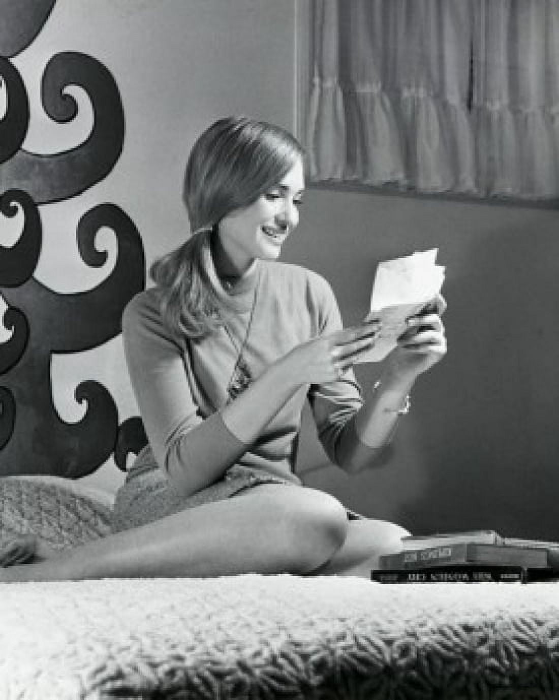 Teenage girl sitting on the bed and reading a letter 1968 Canvas Art - (18 x 24)