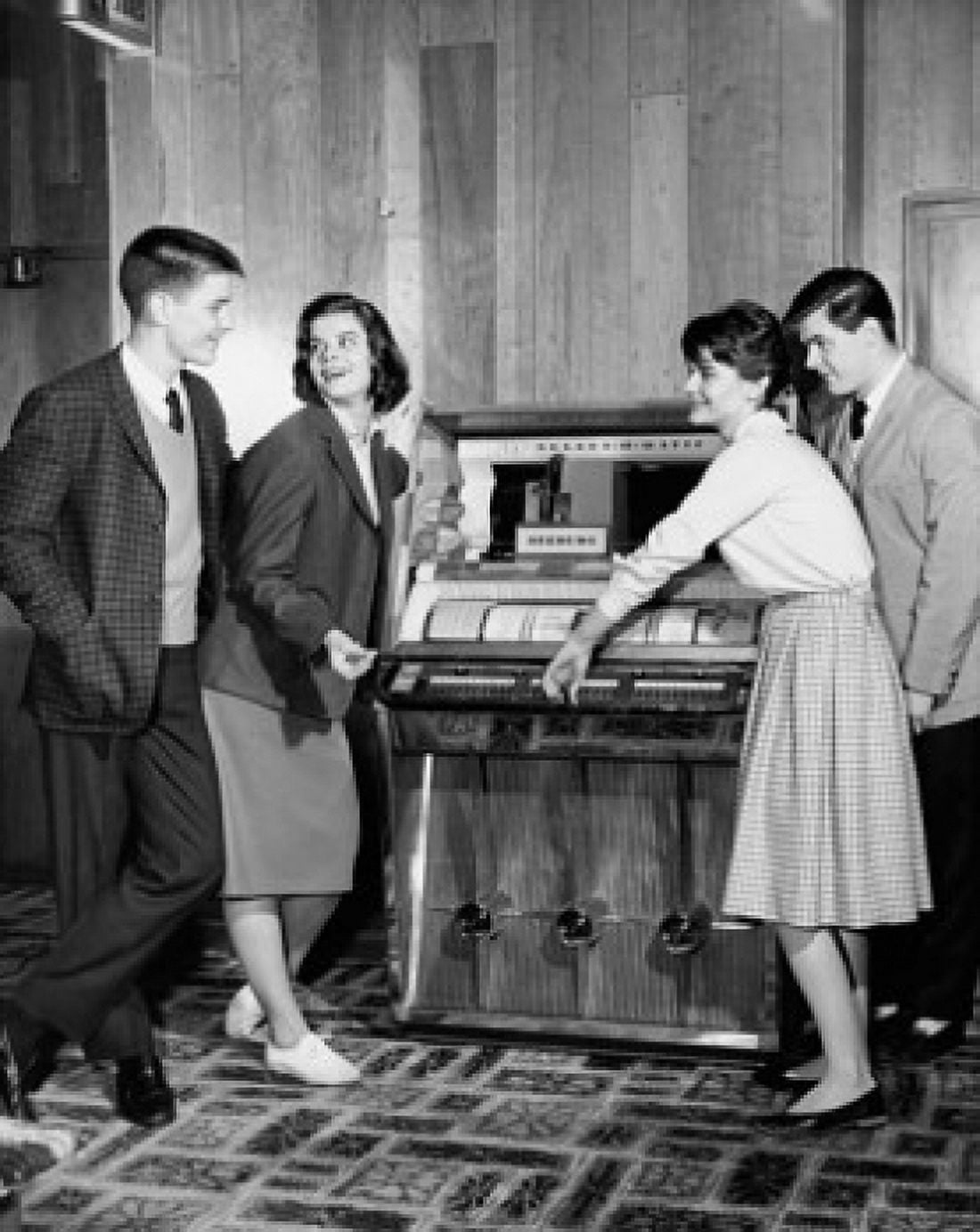 Teenagers standing near a jukebox Canvas Art - (18 x 24)