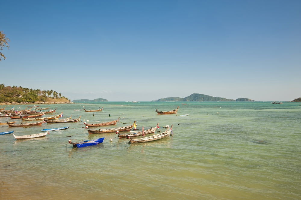 Thailand Phuket Rawaii Beach Longtail boats along the shoreline Land in distance Canvas Art - Bill Brennan Design Pics (38 x 24)