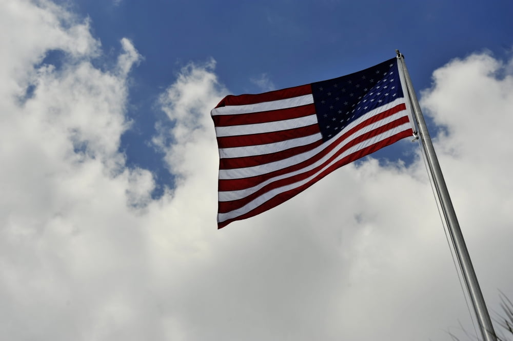 The American Flag blowing in the breeze against a cloudy sky Canvas Art - Stocktrek Images (35 x 23)