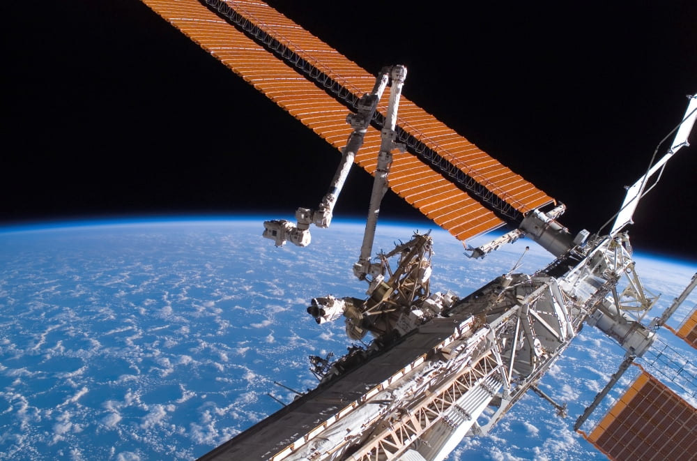 The Canadarm2 and solar array panel wings on the International Space Station Canvas Art - Stocktrek Images (34 x 23)