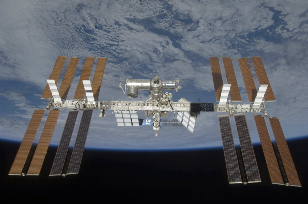 The International Space Station backdropped by the blackness of space and Earths horizon Canvas Art - Stocktrek Images (35 x 23)