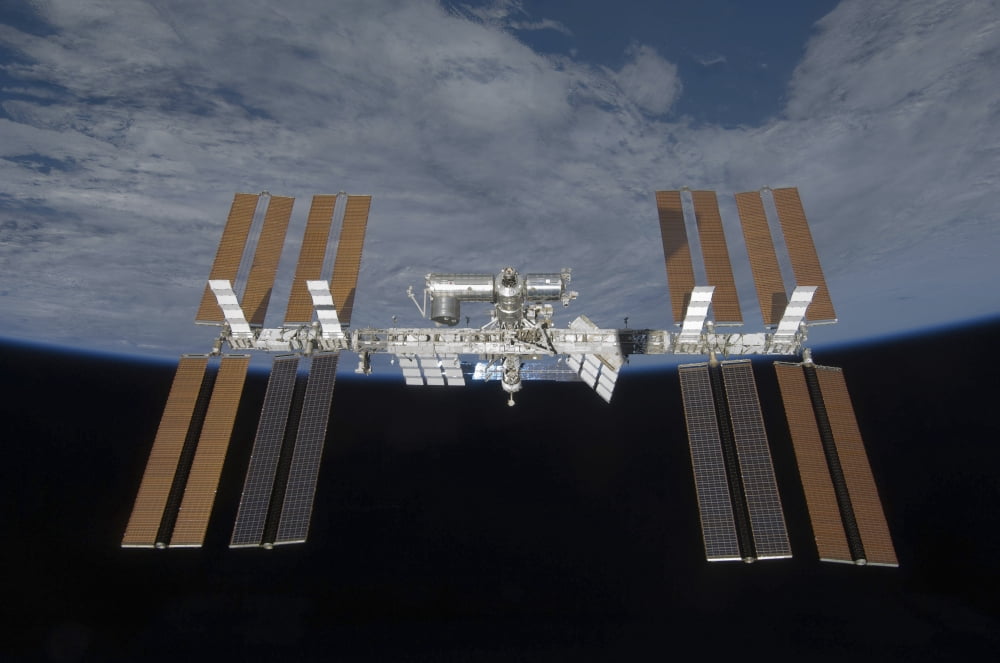 The International Space Station backdropped by the blackness of space and Earths horizon Canvas Art - Stocktrek Images (35 x 23)