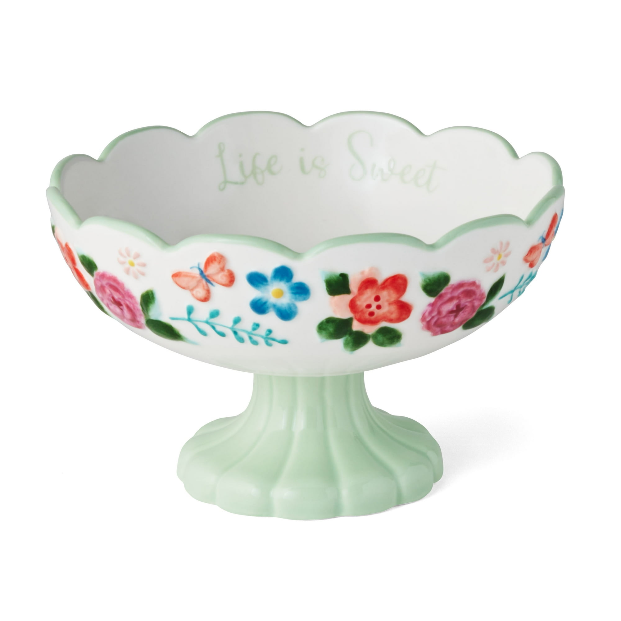 A white candy bowl with a green pedestal and flowers on it