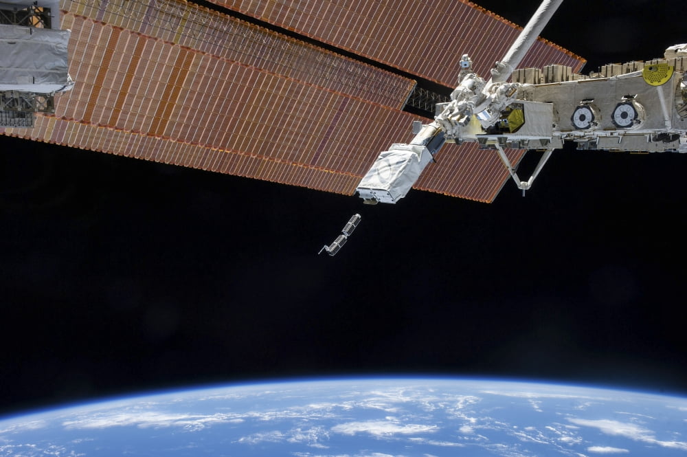 The Small Satellite Orbital Deployer in the grasp of a robotic arm Canvas Art - Stocktrek Images (34 x 23)