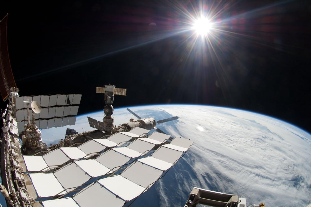 The bright sun a portion of the International Space Station and Earths horizon Canvas Art - Stocktrek Images (35 x 23)