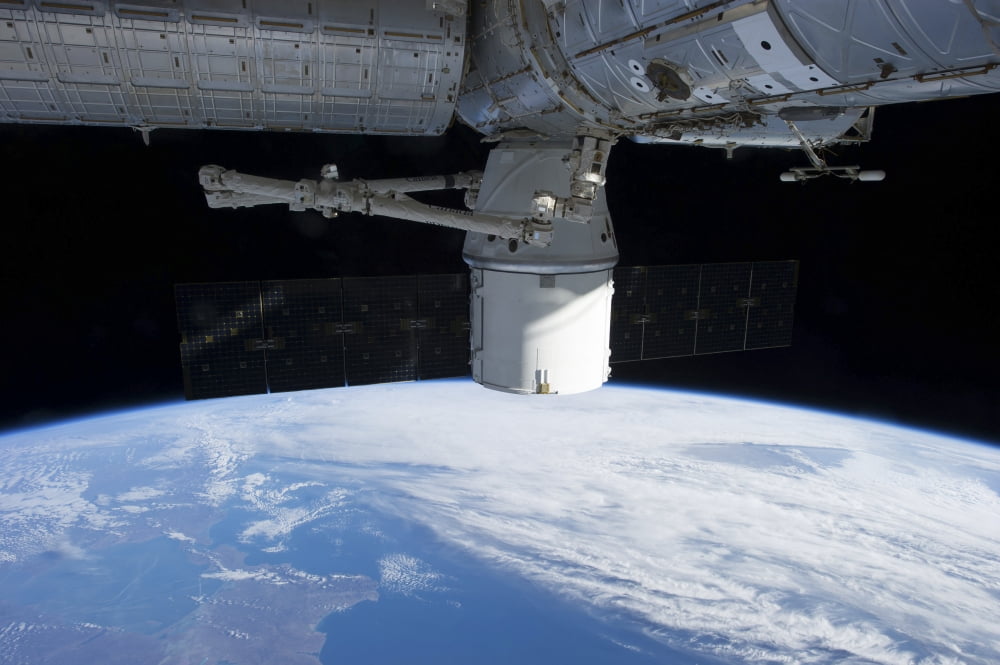 The docking of SpaceX Dragon to the International Space Station above Earth Canvas Art - Stocktrek Images (34 x 23)