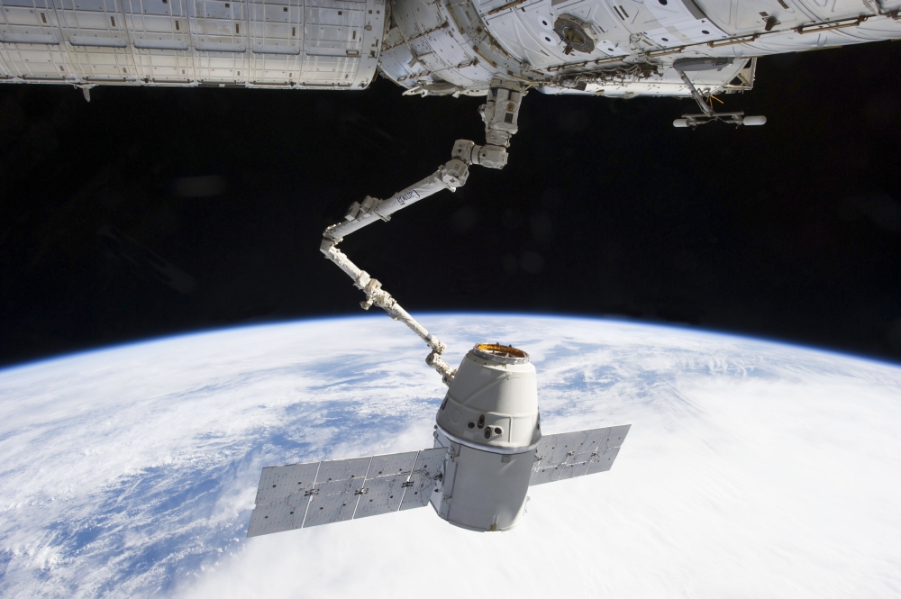 The docking of SpaceX Dragon to the International Space Station above Earth Canvas Art - Stocktrek Images (34 x 23)
