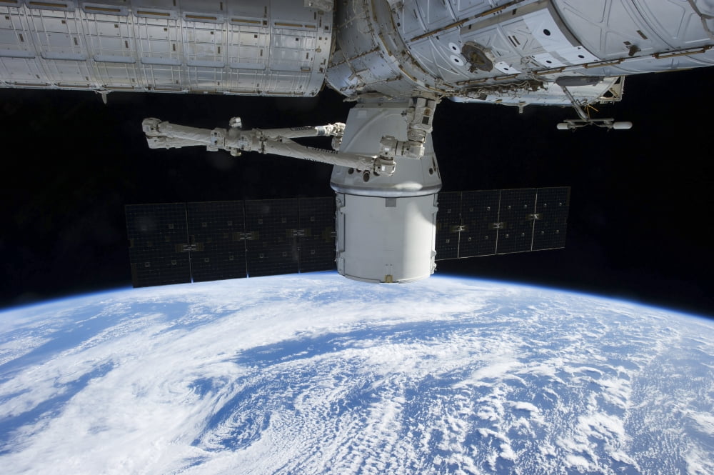 The docking of SpaceX Dragon to the International Space Station above Earth Canvas Art - Stocktrek Images (34 x 23)