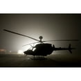 thumbnail image 1 of The illumination from the bright light silhouettes a OH-58D Kiowa helicopter during thick fog Poster Print, 1 of 2