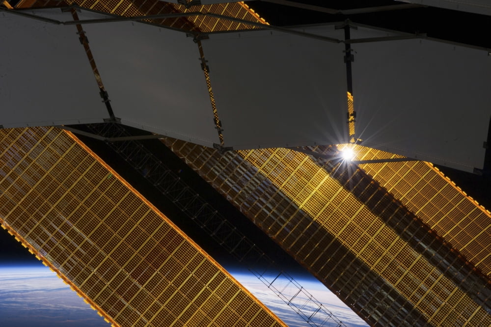 The sun shines through the solar panels on the International Space Station Canvas Art - Stocktrek Images (35 x 23)
