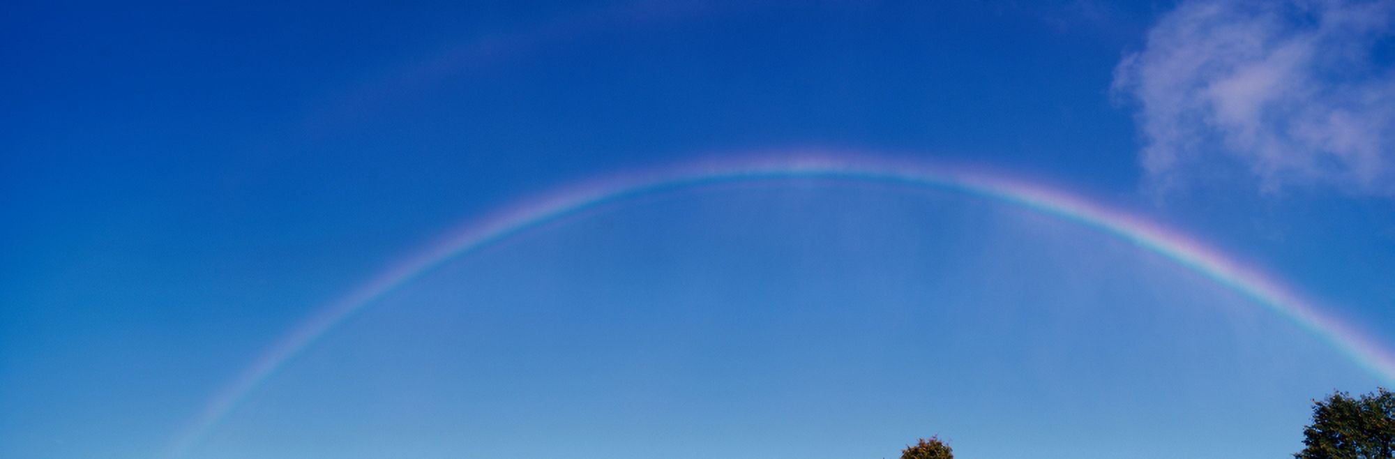 This is a rainbow against a blue sky with a few white clouds It was taken near Niagara Falls Canvas Art - Panoramic Images (27 x 9)