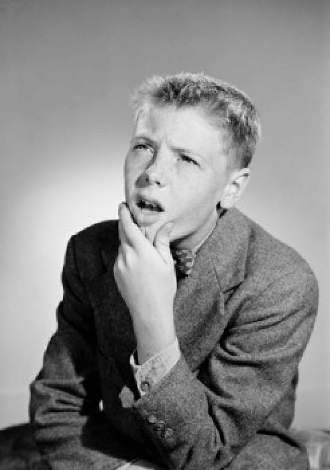 Thoughtful boy with hand on chin looking up studio shot Canvas Art - (24 x 36)