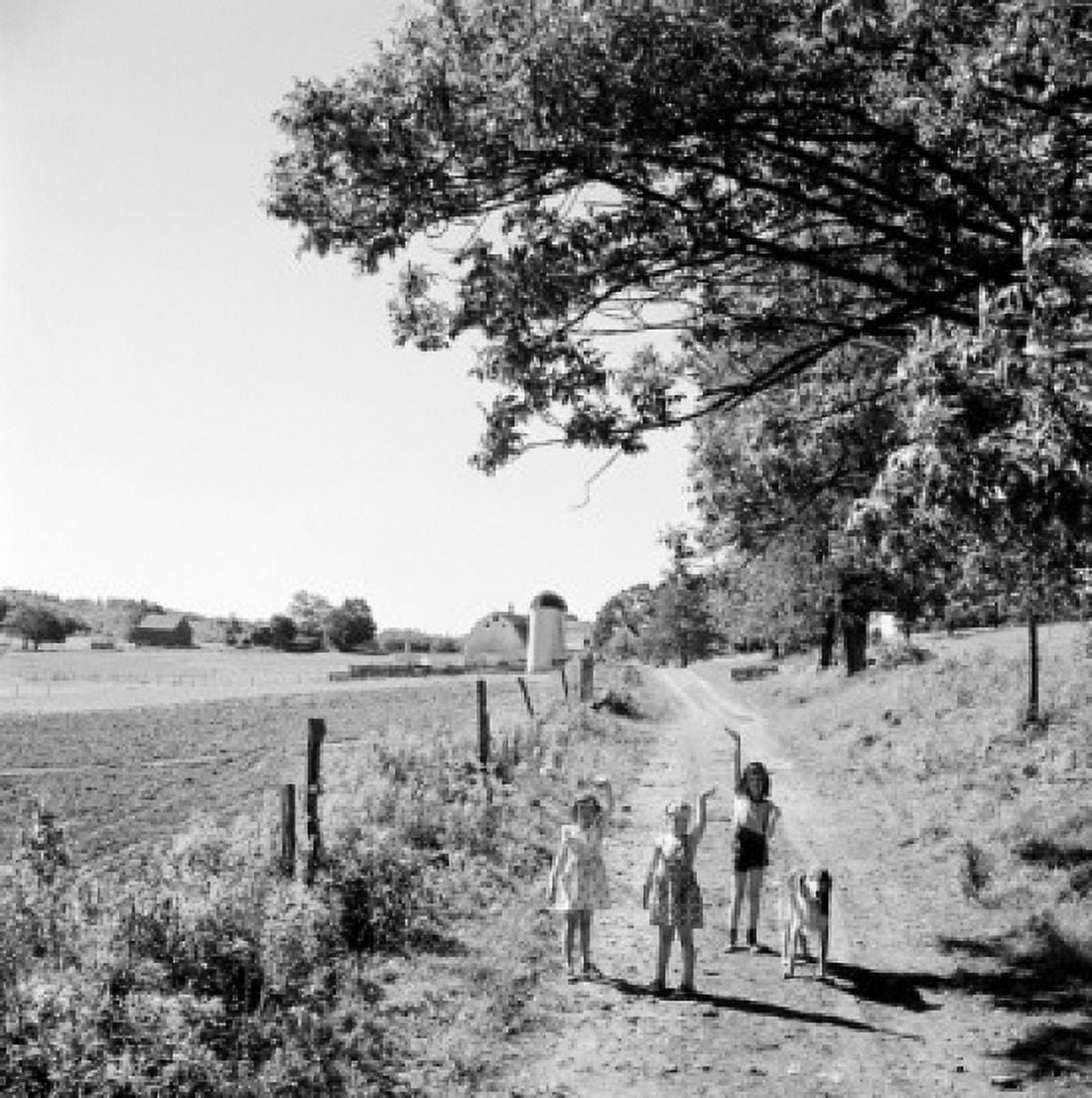 Three girls standing on dirt road and waving Canvas Art - (24 x 36)