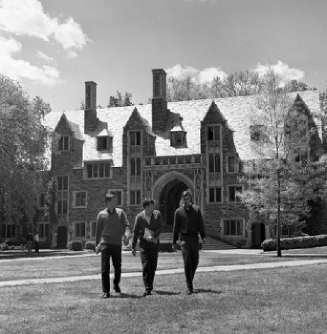 Three male students walking on lawn in front of university building Canvas Art - (18 x 24)