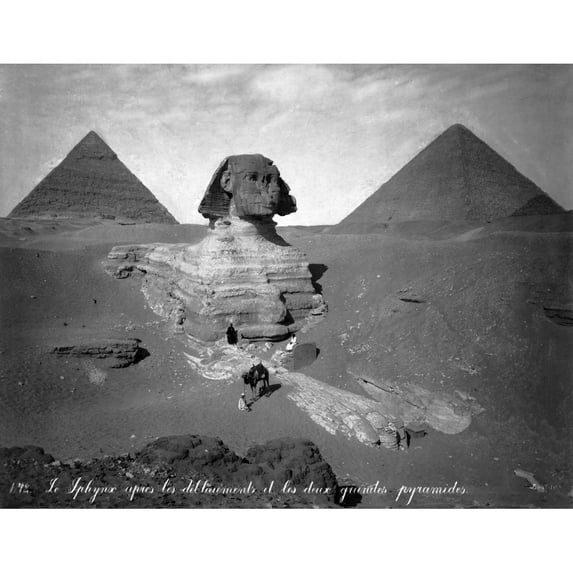 Three men, one with camel, on paw of the Sphinx, two pyramids in background. Poster Print by Felix Bonfils (18 x 24)