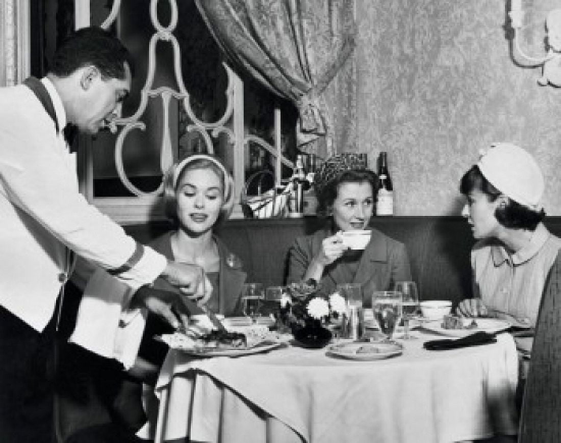 Three young women sitting together in restaurant Canvas Art - (18 x 24)
