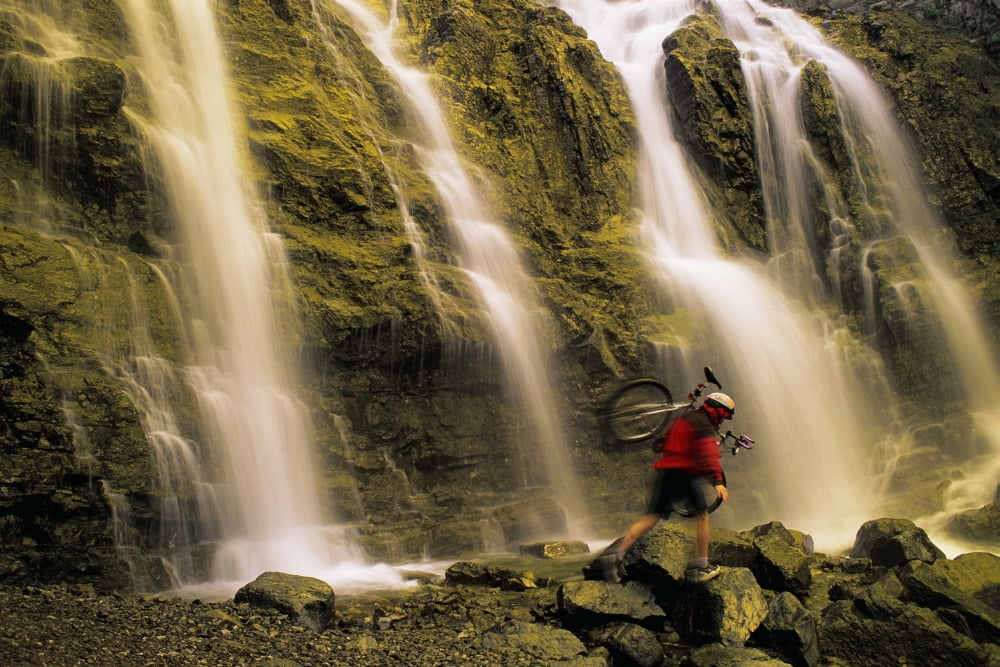 Time Delay Of Waterfall With Cyclist Carrying Bicycle Canvas Art - Don Hammond Design Pics (17 x 11)
