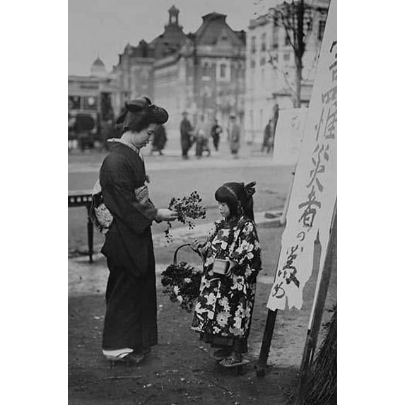 Toddler in front of Kanban Shop sign sells flowers to a kimono wearing young lady who picks them from a basket that the little girls is holding. Poster Print by unknown (24 x 36)