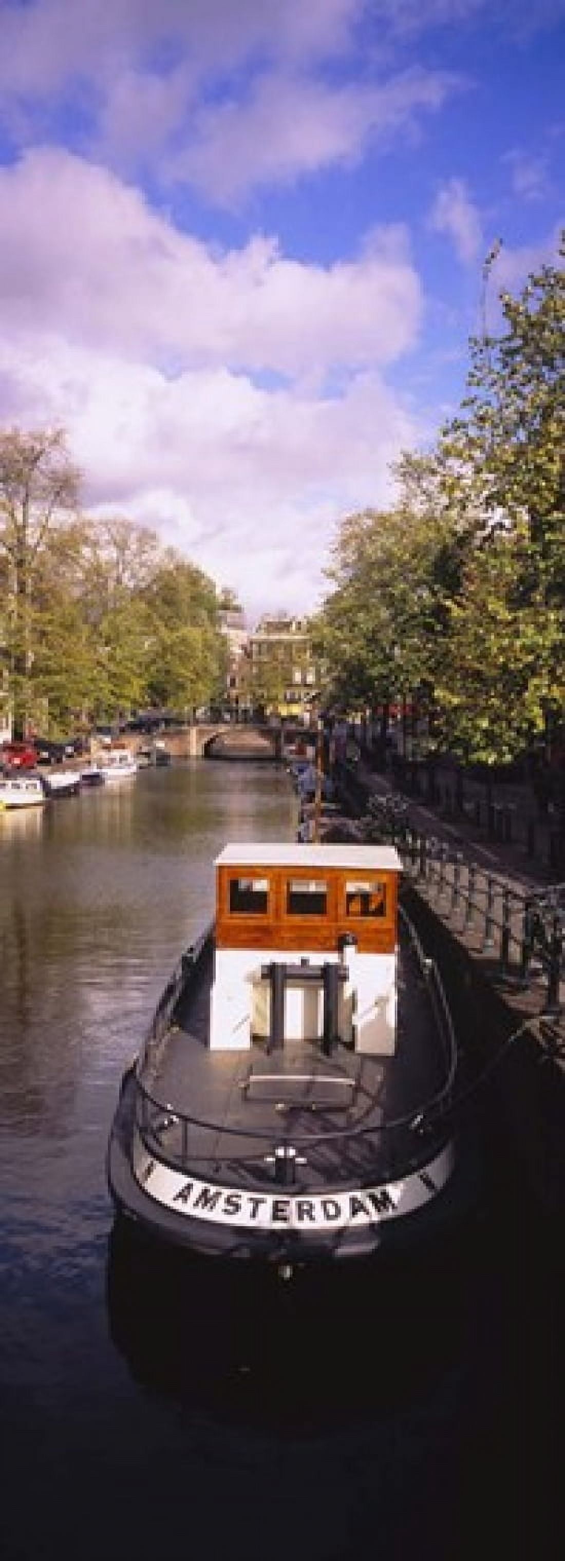 Tourboat docked in a channel Amsterdam Netherlands Canvas Art - Panoramic Images (18 x 7)