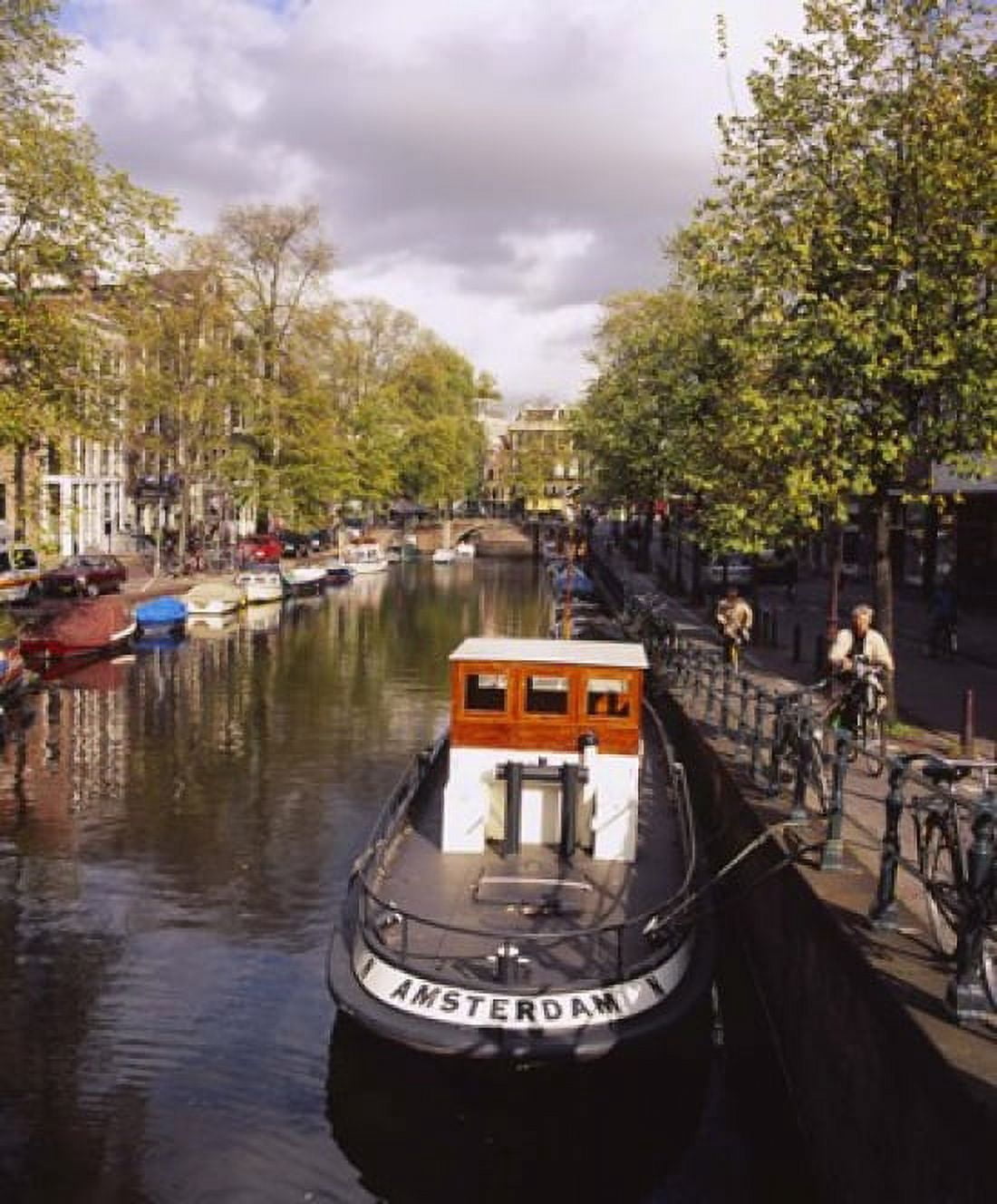 Tourboat docked in a channel Amsterdam Netherlands Canvas Art - Panoramic Images (20 x 24)