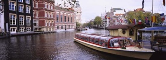Tourboat in a channel Amsterdam Netherlands Canvas Art - Panoramic Images (36 x 13)