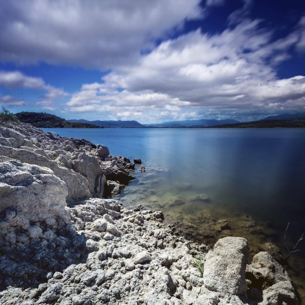 Tranquil lake and rocky shore against cloudy sky Sardinia Italy Canvas Art - Evgeny KuklevStocktrek Images (29 x 29)