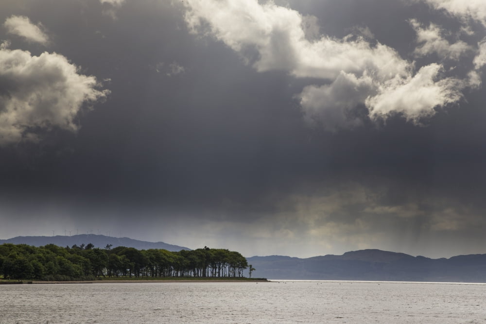 Trees and mountains along the coastline under storm clouds Otter Ferry Scotland Canvas Art - John Short Design Pics (19 x 12)