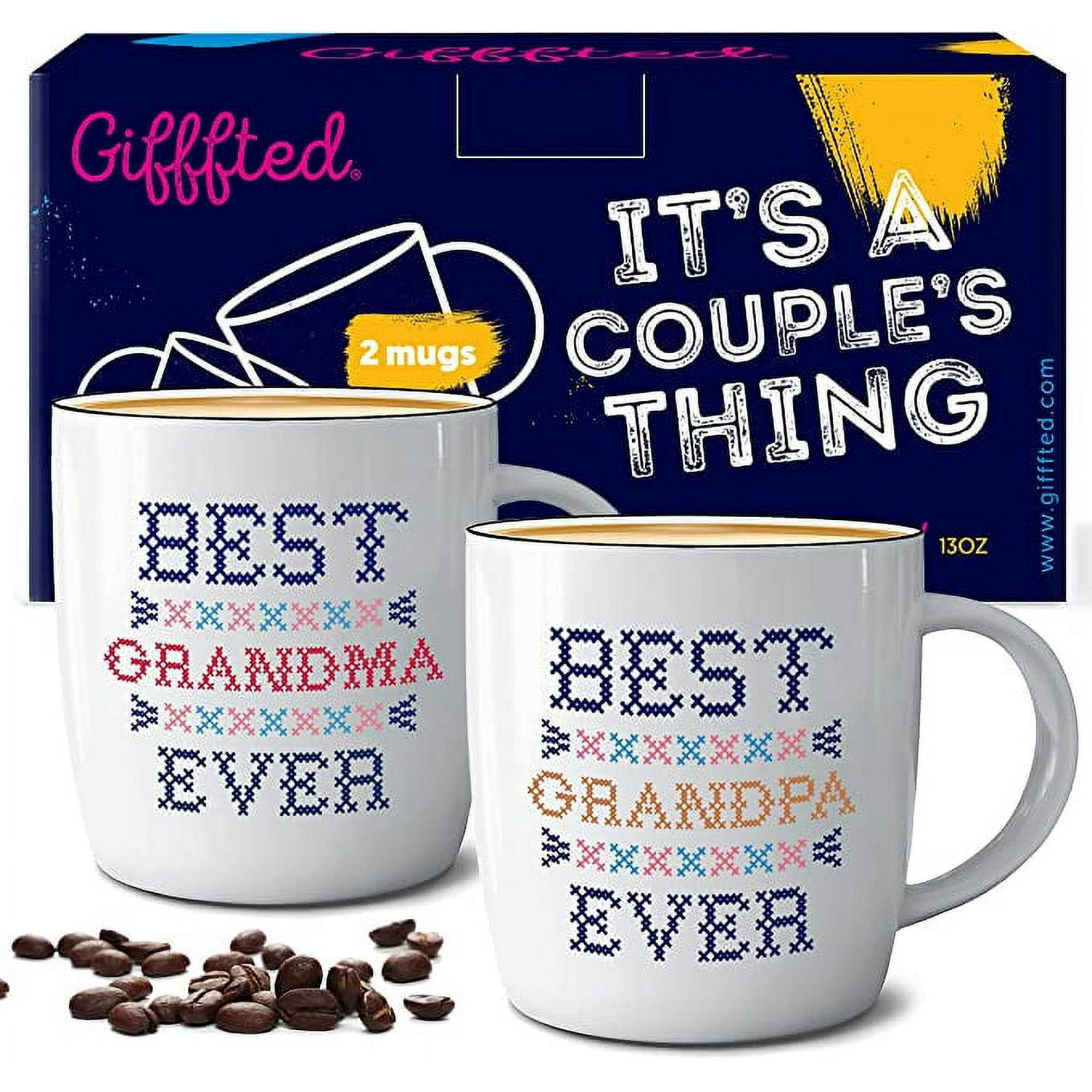 Two white mugs and a pile of coffee beans in front of a blue box