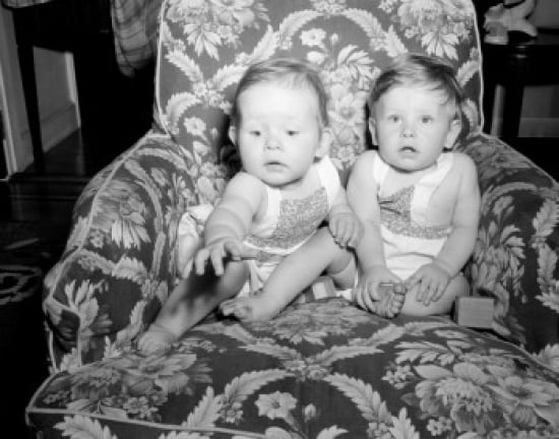 Two baby girls sitting on armchair Canvas Art - (24 x 36)