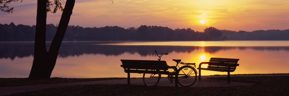 Two benches with a bicycle along a lake Reeds Lake Grand Rapids Michigan USA Canvas Art - Panoramic Images (36 x 12)