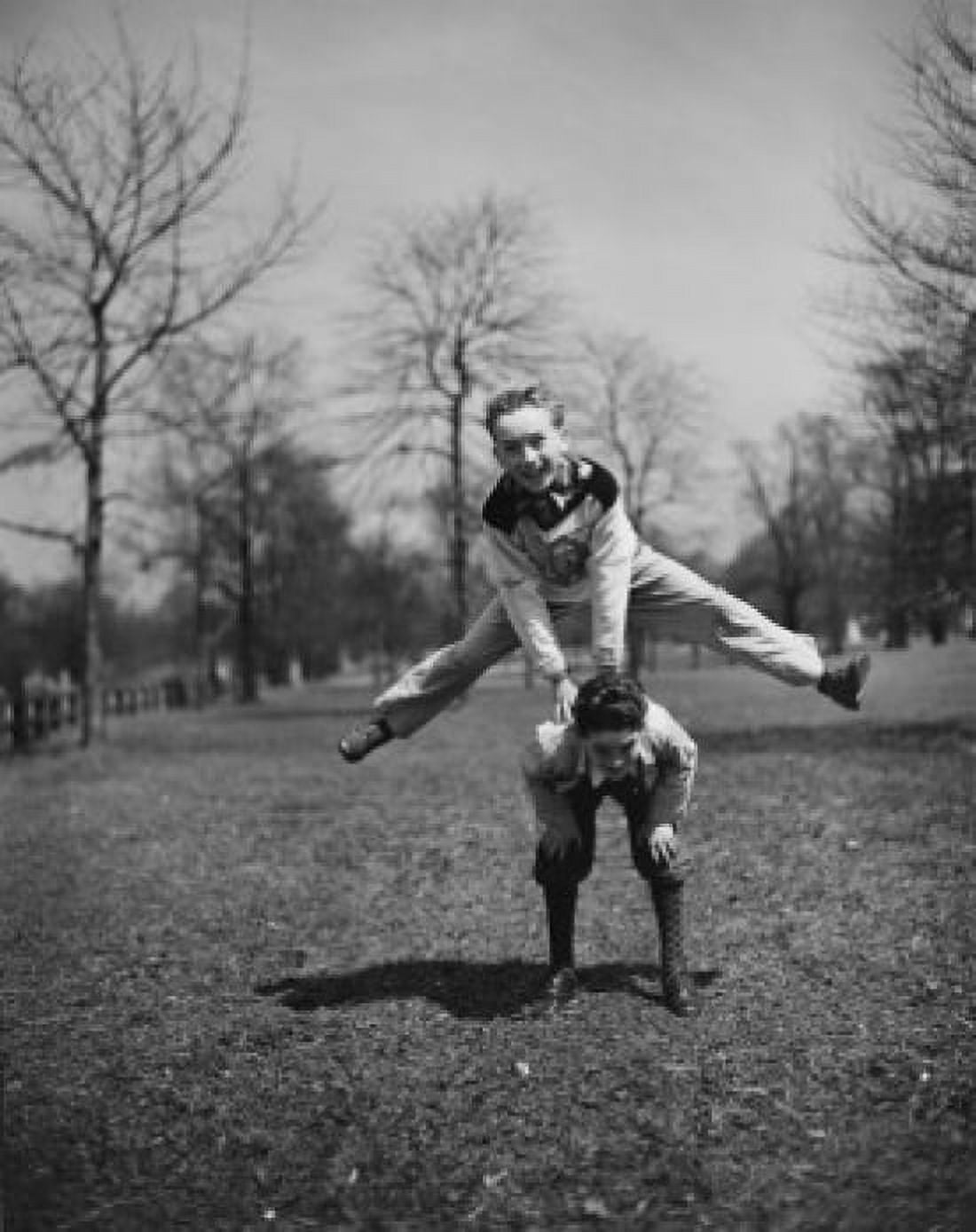 Two boys leapfrogging in park Canvas Art - (18 x 24)