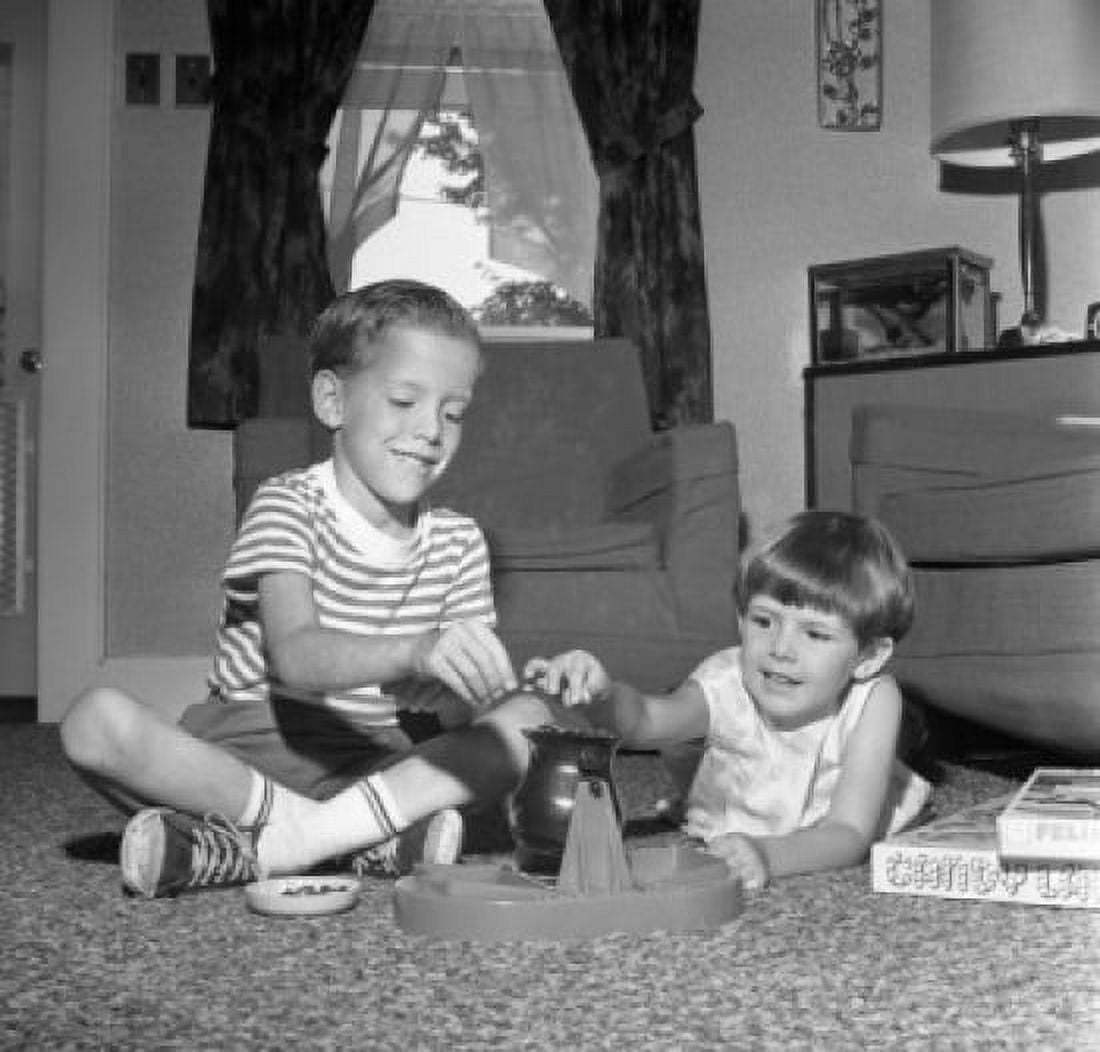 Two boys playing with toy game on living room floor Canvas Art - (24 x 36)