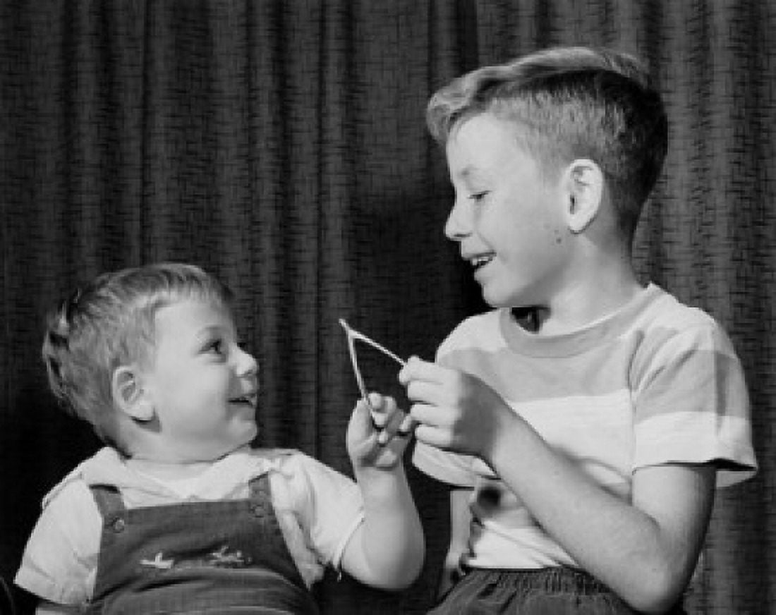 Two boys pulling a wishbone and smiling Canvas Art - (24 x 36)
