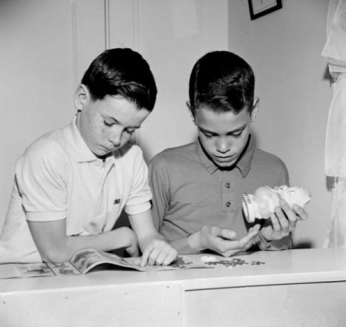 Two boys reading magazine and taking out money from money-box Canvas Art - (24 x 36)