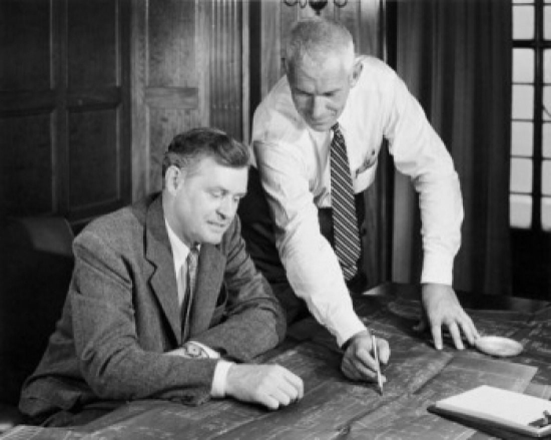 Two businessmen discussing blueprint in office Canvas Art - (24 x 36)