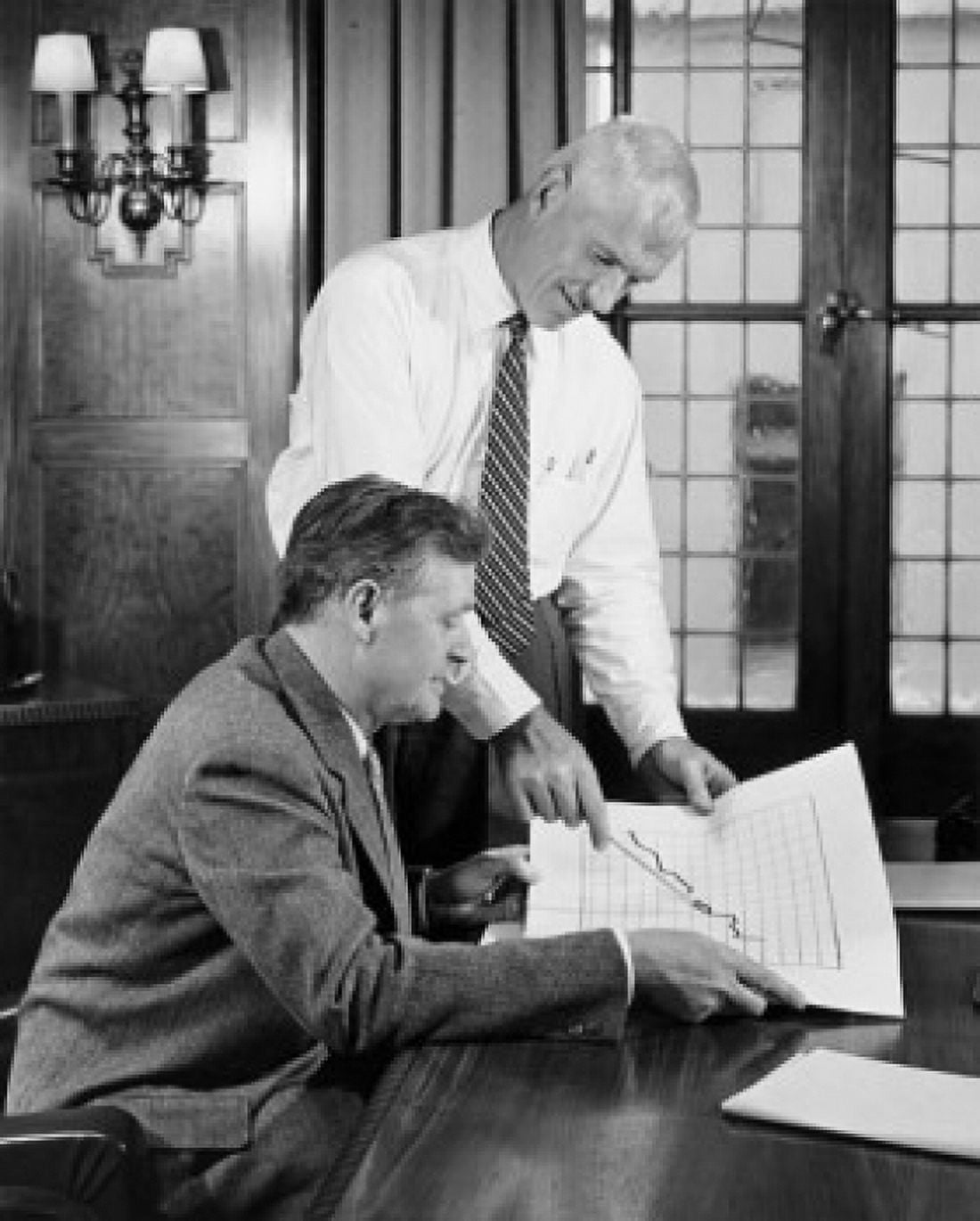 Two businessmen discussing line graph in office Canvas Art - (18 x 24)